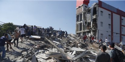 Cali (Colombia), 10/08/2026.- Personas caminan sobre los escombros de un edificio colapsado este lunes